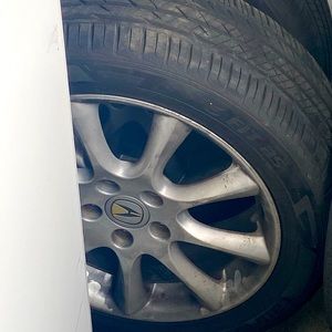 Acura rims with a tire on it four tires
